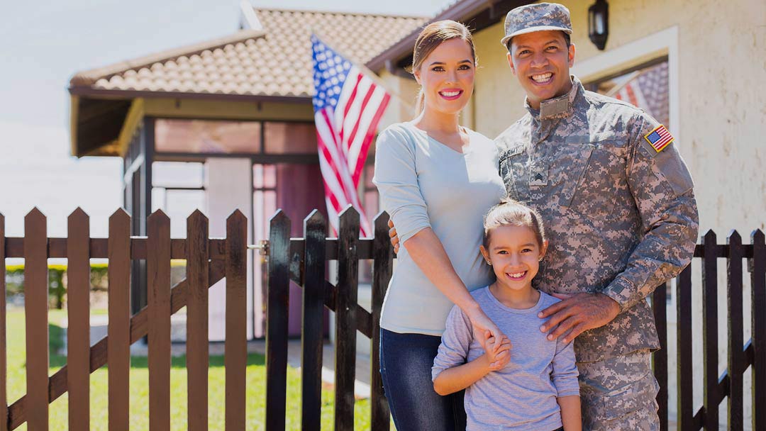 Photo of an American soldier, wife, and daughter in front of home.